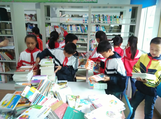 学生亲身参与爱心图书室上架
